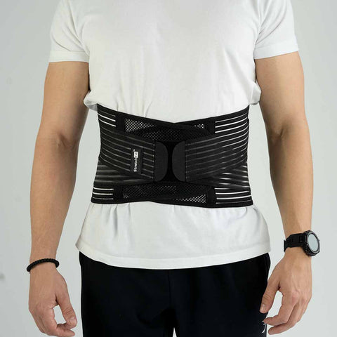 muž v bielom tričku má oblečený bedrový pás lumbarflex